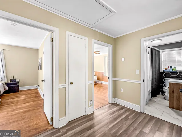 a view of a hallway with wooden floor and dining room view