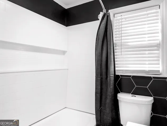 a bathroom with a toilet a sink and a mirror