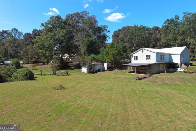 a view of a house with a yard and sitting area