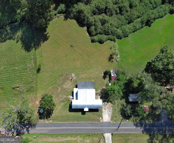 an aerial view of a house with a yard basket ball court and outdoor seating