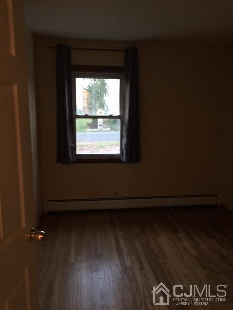 65 Tower Road Edison, NJ 08820 - Photo 8 of 11 an empty room with wooden floor and a window