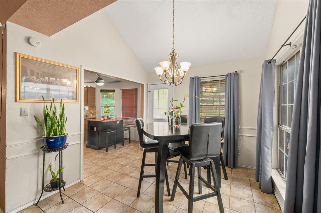 916 Danforth Place Arlington, TX 76017 - Photo 11 of 30 Dining area featuring vaulted ceilings, a chandelier, and tile flooring