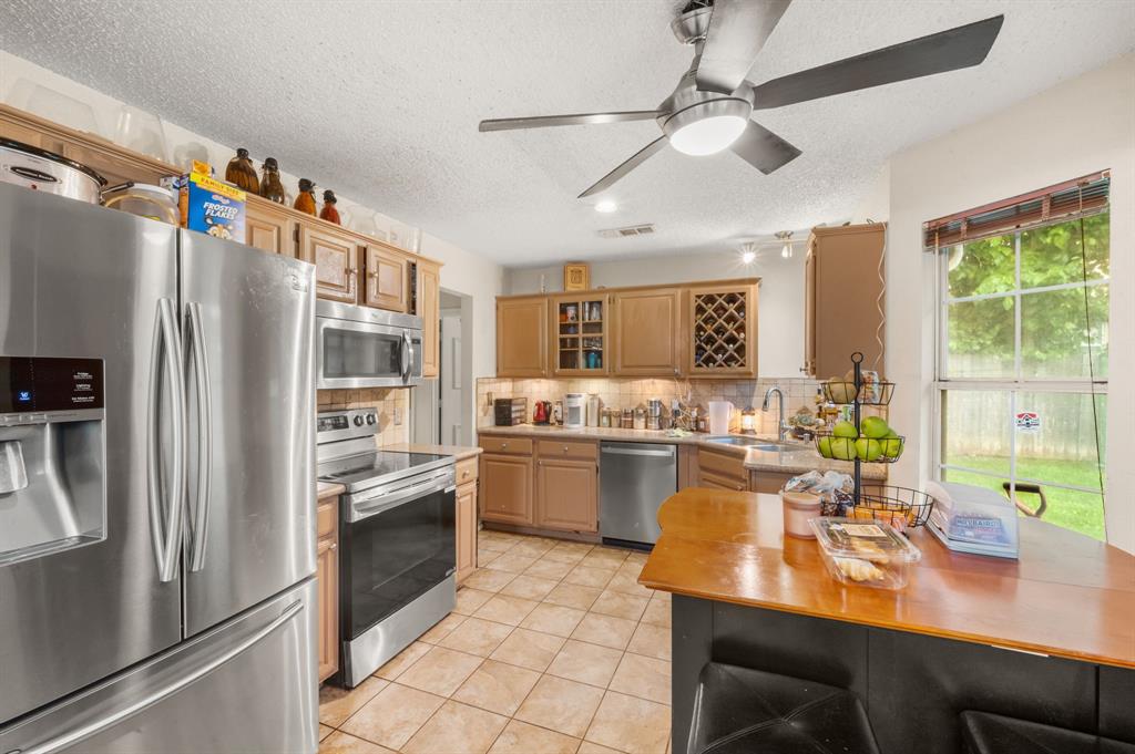 916 Danforth Place Arlington, TX 76017 - Photo 12 of 30 Kitchen featuring stainless steel appliances, wood-finish cabinetry, tile flooring, and a ceiling fan