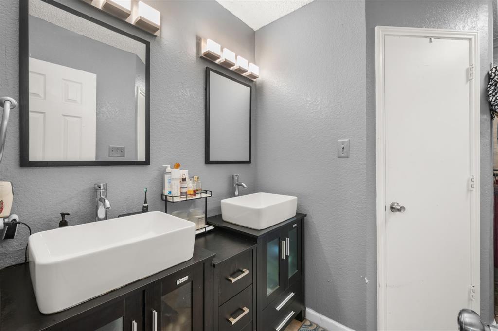 916 Danforth Place Arlington, TX 76017 - Photo 17 of 30 Dual vessel sinks with modern fixtures, set atop dark wood-finish vanity cabinets