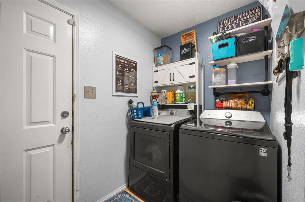 916 Danforth Place Arlington, TX 76017 - Photo 22 of 30 Dedicated laundry area featuring a paneled door, built-in shelving, white cabinetry, and wall-mounted storage solutions