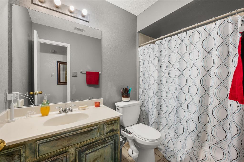 916 Danforth Place Arlington, TX 76017 - Photo 23 of 30 Bathroom featuring a vanity with an integrated sink, a large wall-mounted mirror, and a three-light fixture