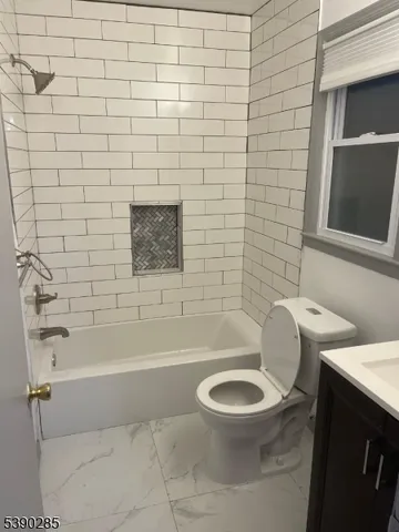 a white toilet and tub sitting next to a bathroom sink