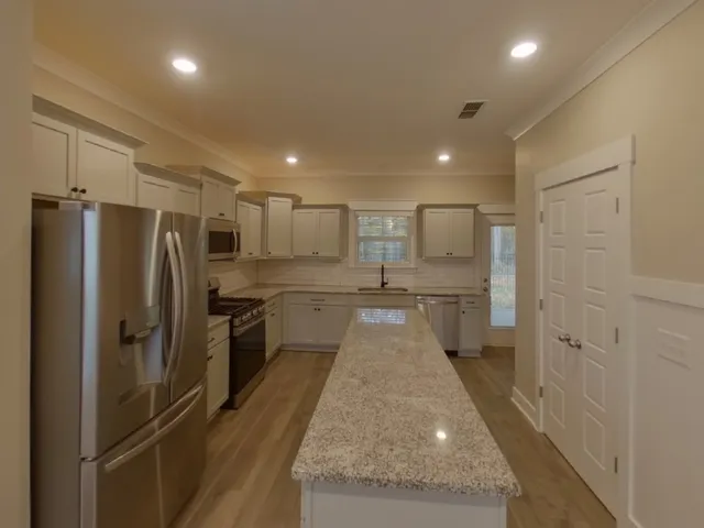 a large kitchen with a refrigerator and a sink