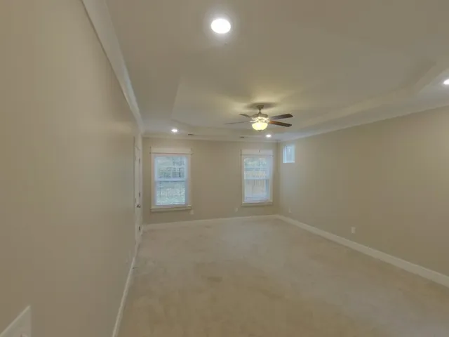 an empty room with windows and fan