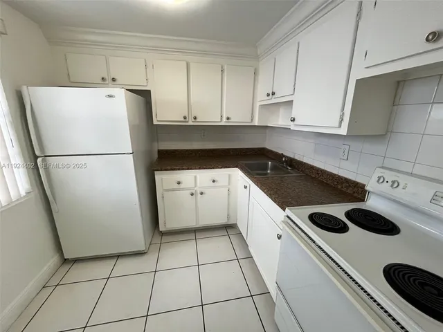 a kitchen with a refrigerator a stove a sink and cabinets