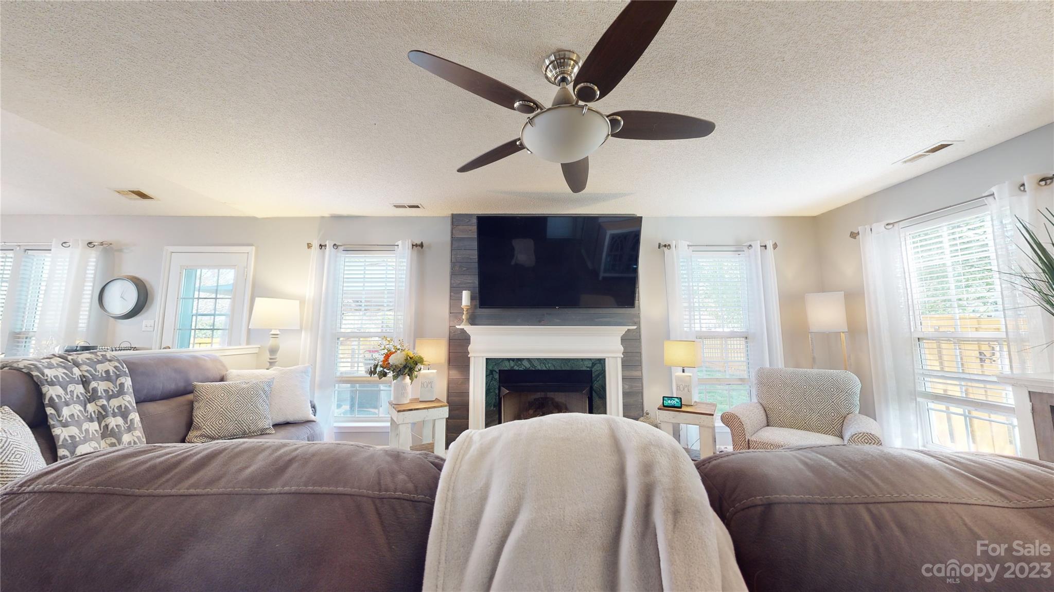 1007 Great Falls Drive Monroe, NC 28110 - Photo 19 of 45 a living room with a fireplace furniture a flat screen tv and a large window