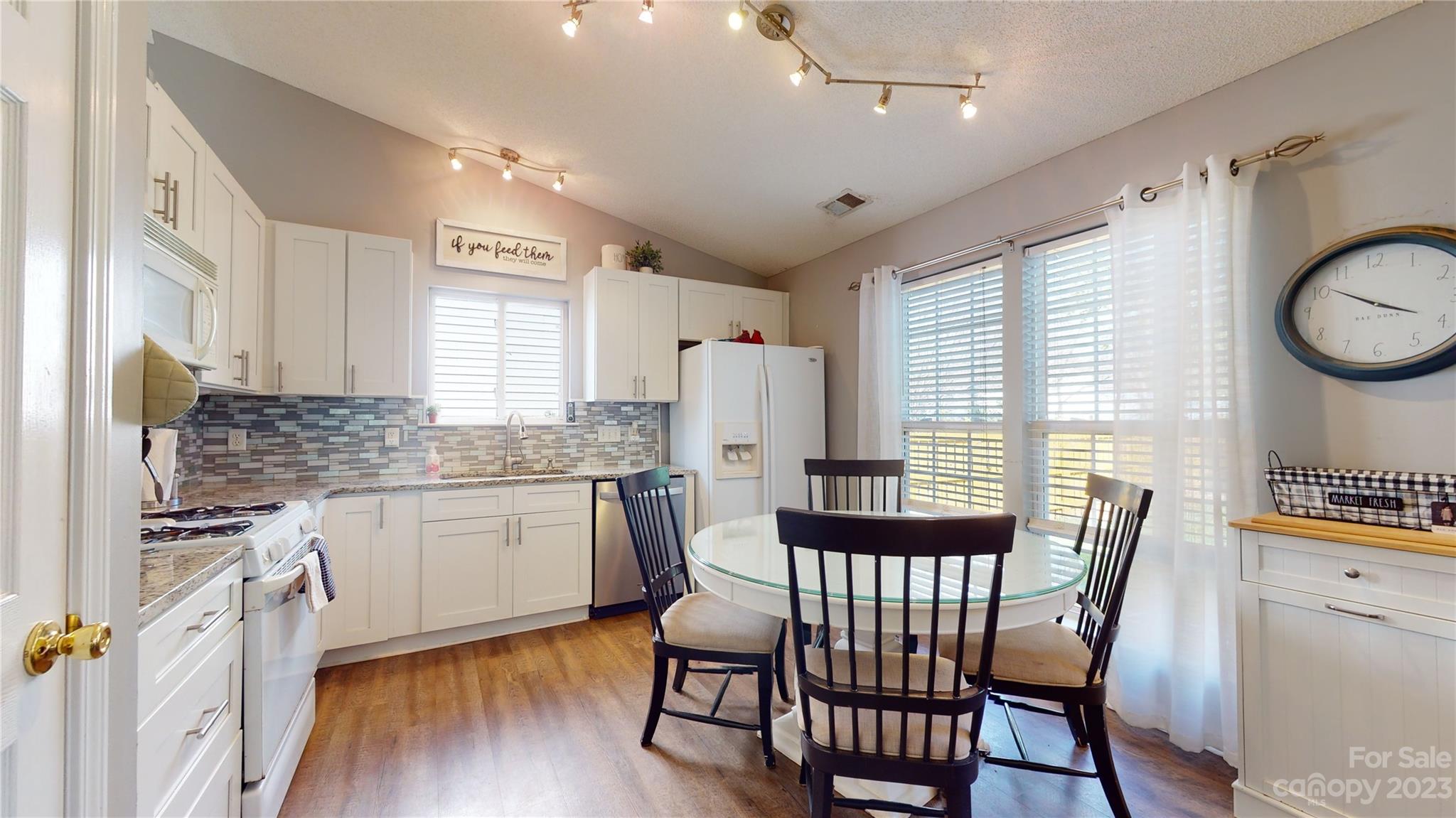 1007 Great Falls Drive Monroe, NC 28110 - Photo 6 of 45 a kitchen with granite countertop a dining table chairs cabinets a sink and a window