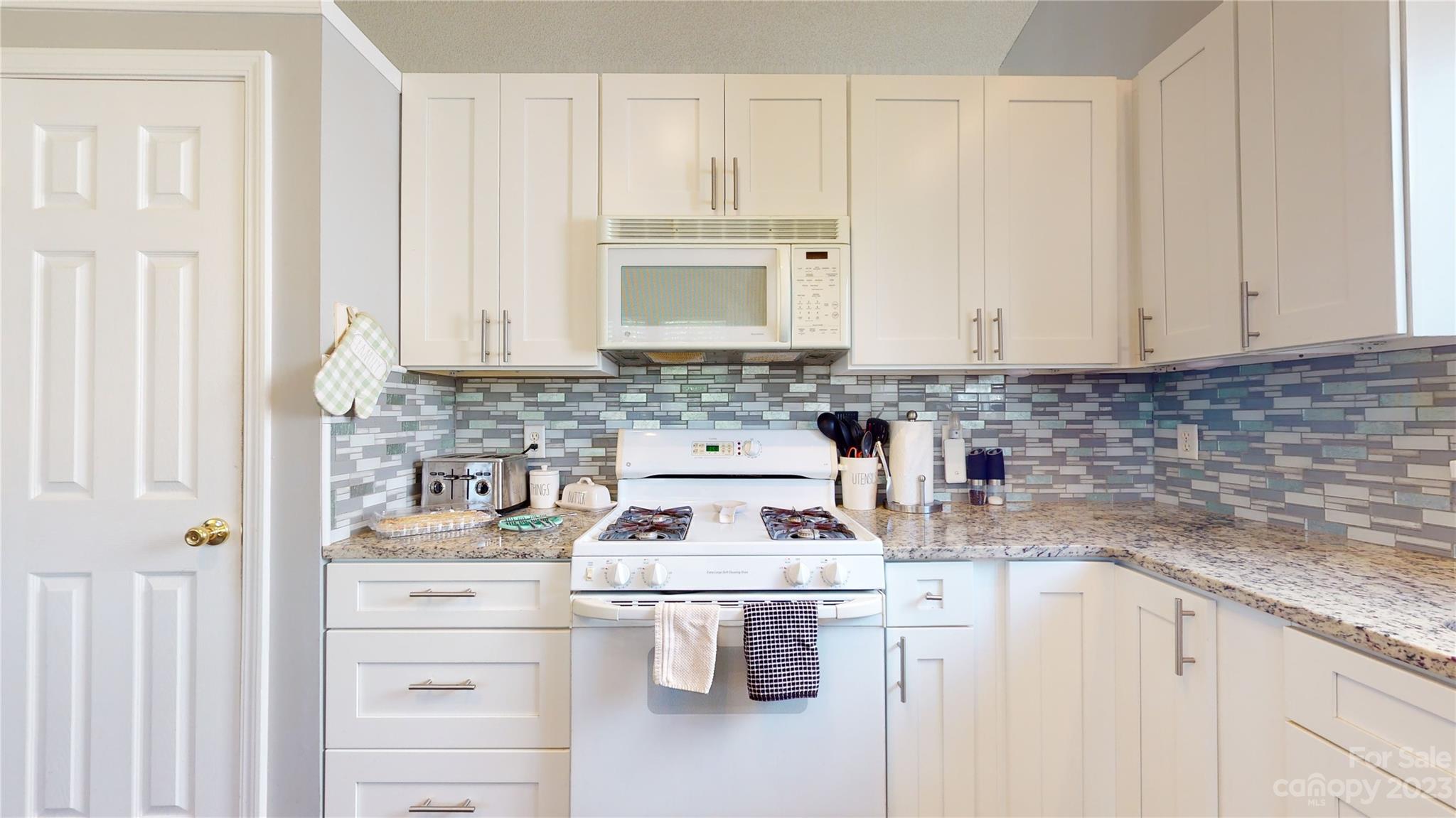 1007 Great Falls Drive Monroe, NC 28110 - Photo 7 of 45 a kitchen with stainless steel appliances granite countertop white cabinets and a stove