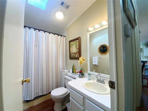 a bathroom with a sink a toilet a shower and a mirror