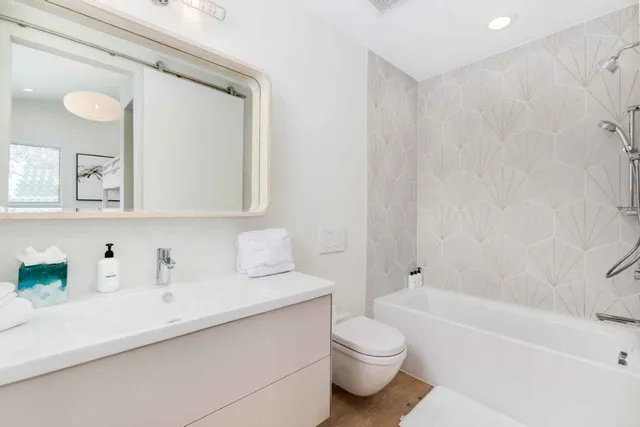 a bathroom with a toilet a sink a mirror and bathtub