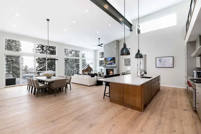 a living room with furniture kitchen view and a wooden floor