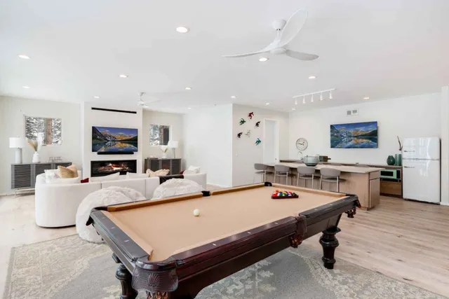 a room with furniture pool table flat screen tv and windows