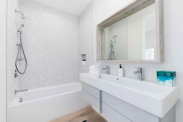 a bathroom with a sink vanity tub and shower