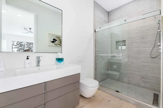 a bathroom with a sink a toilet and shower