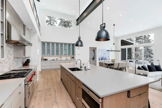 a kitchen with stainless steel appliances a sink a stove and a wooden floors
