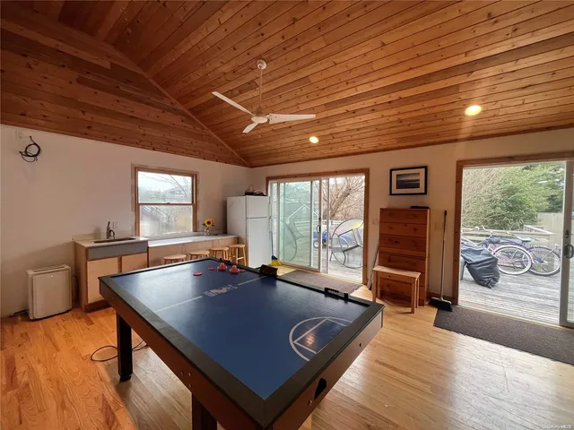 a living room with furniture a flat screen tv and floor to ceiling window
