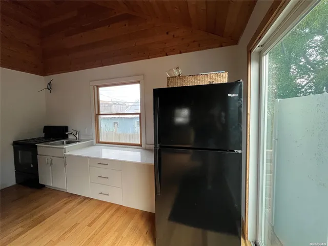 a kitchen with a refrigerator and white cabinets
