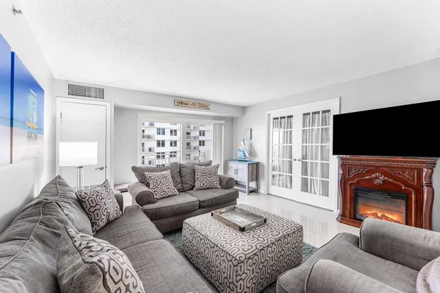 a living room with furniture a flat screen tv and a window