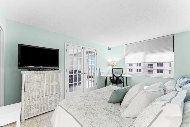 a bathroom with a granite countertop sink vanity mirror and toilet