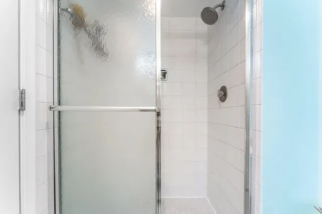 a bedroom with a bed a lamp and a large window