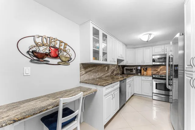a kitchen with stainless steel appliances granite countertop a stove and cabinets