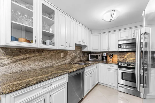 a kitchen with granite countertop a stove top oven microwave and cabinets