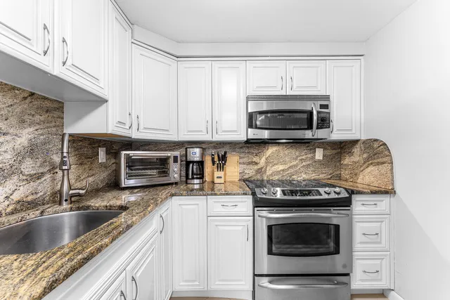 a kitchen with stainless steel appliances granite countertop a sink and cabinets