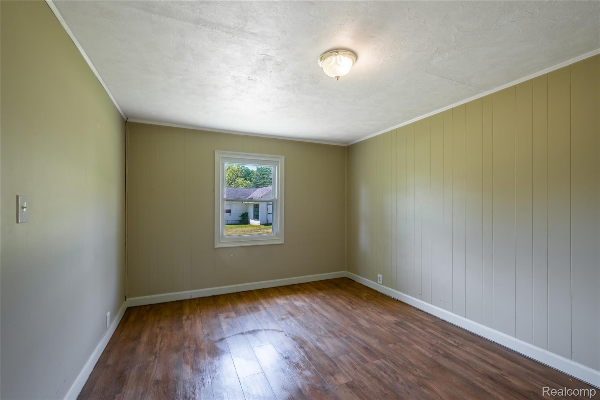 12238 Jennings Road Linden, MI 48451 - Photo 19 of 33 Interior room featuring wood-finish flooring, a single window with white trim, and a flush-mount ceiling light
