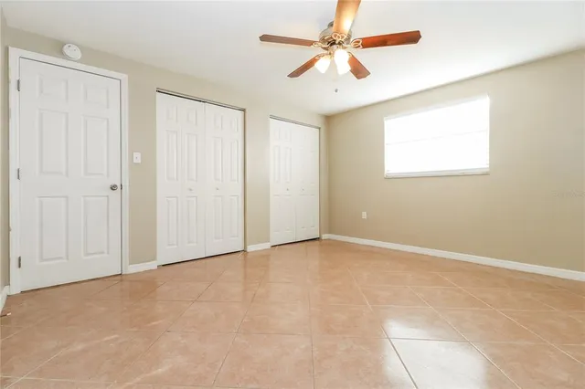 an empty room with fan and windows