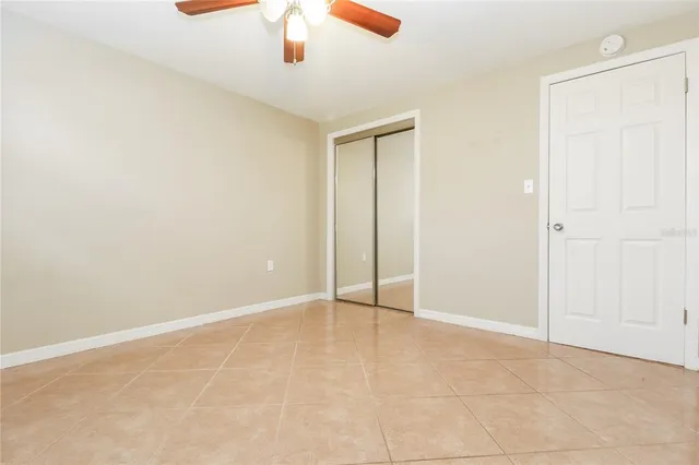 an empty room with chandelier fan