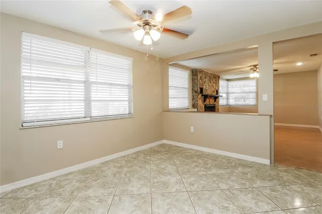 a view of a big room with windows and chandelier fan