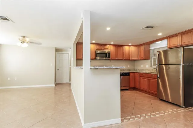 a kitchen with stainless steel appliances granite countertop a refrigerator and a sink