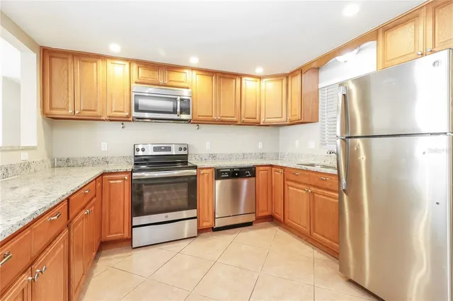 a kitchen with stainless steel appliances granite countertop a refrigerator sink and stove