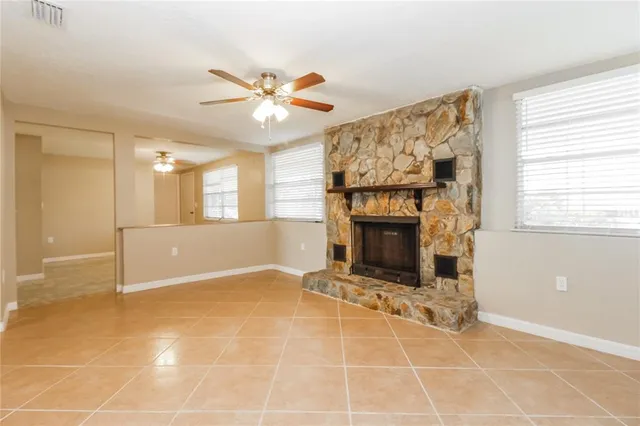 a view of an empty room with a fireplace and a window