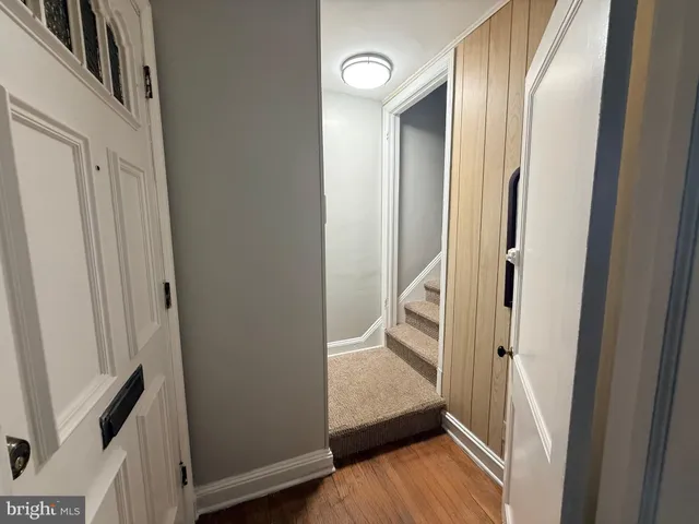 a view of a hallway with wooden floor and staircase