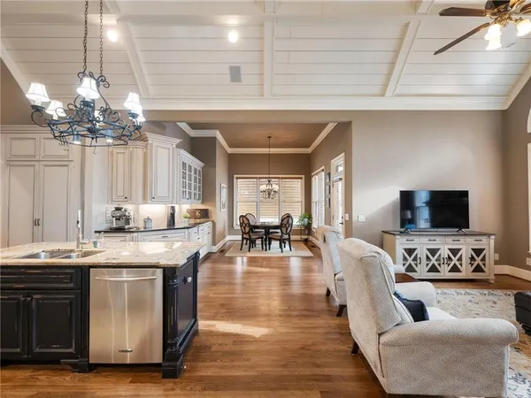 a kitchen with stainless steel appliances granite countertop a kitchen island a stove a table and chairs in it