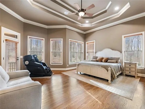 a spacious bedroom with a bed a couch and a large window