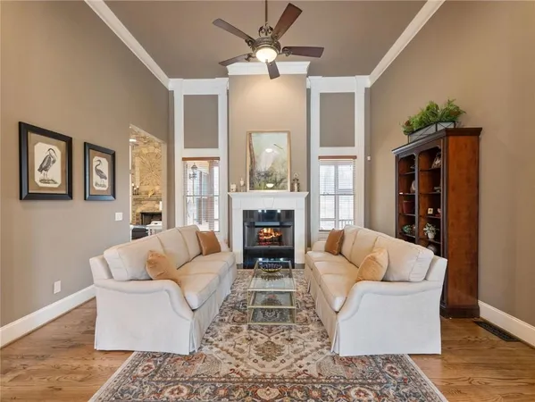 a living room with furniture a fireplace and a chandelier