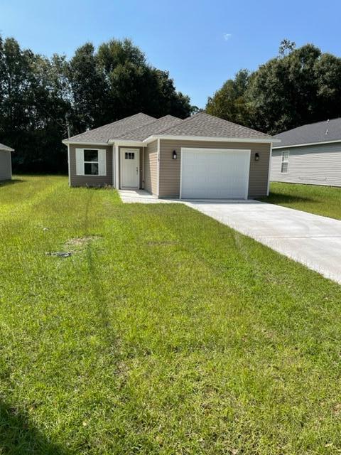 a view of a house with a yard and a garage
