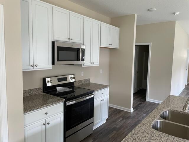 952 Mapoles Street Crestview, FL 32536 - Photo 14 of 23 a kitchen with granite countertop white cabinets and stainless steel appliances