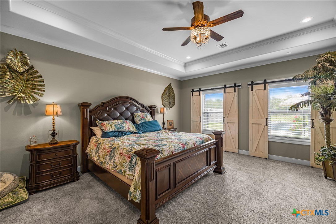 254 Sendera Loop Victoria, TX 77904 - Photo 27 of 48 a bedroom with a bed and a chandelier