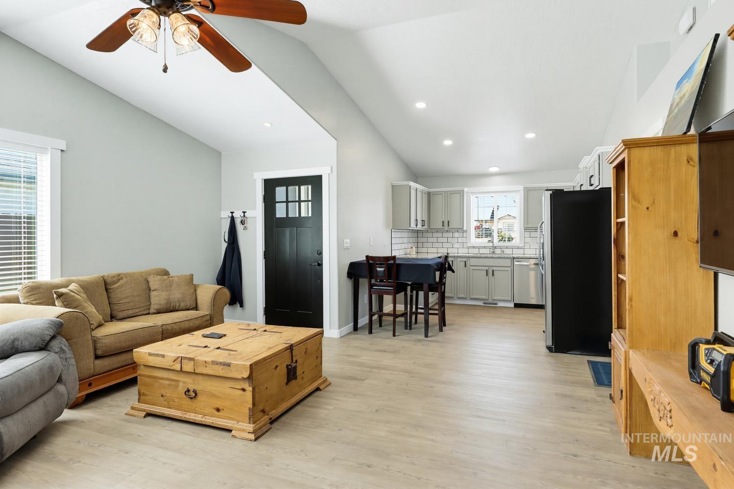 5221 Lockwood Way Caldwell, ID 83607 - Photo 8 of 27 Vaulted ceilings, wood-finish flooring, recessed lighting, and a kitchen featuring grey shaker-style cabinetry with a subway tile backsplash