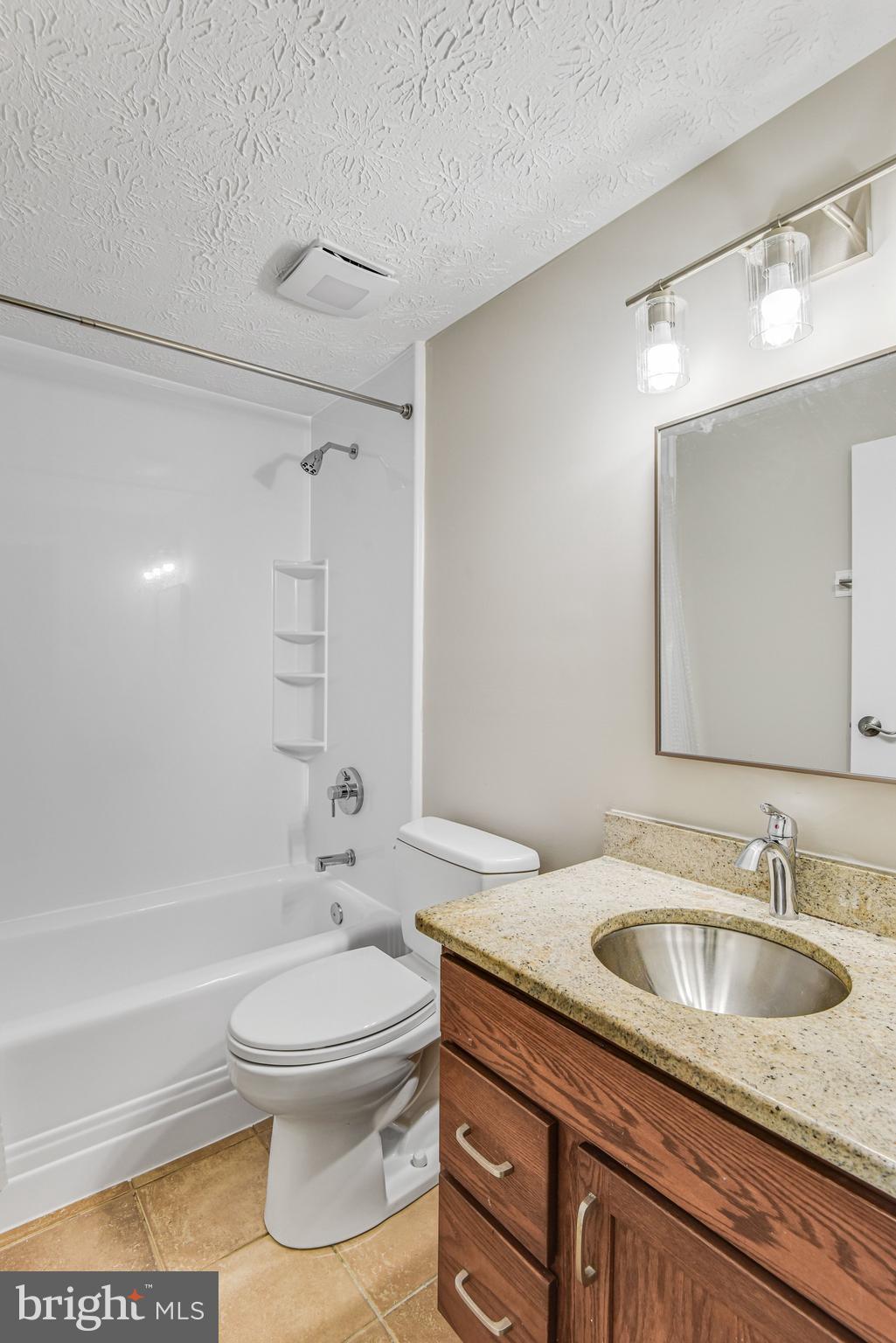 8339 Bark Tree Court Springfield, VA 22153 - Photo 20 of 23 a bathroom with a granite countertop sink a toilet and a bathtub