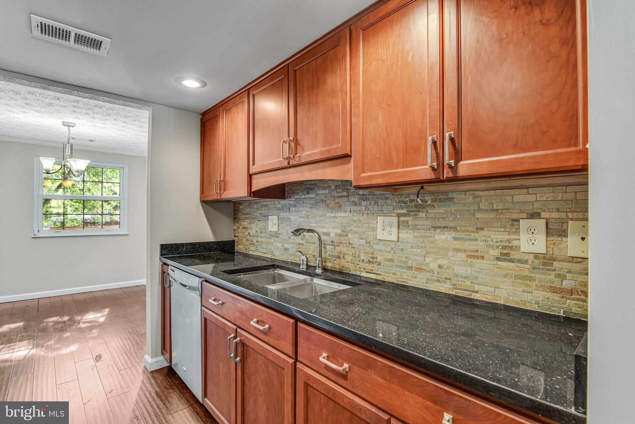 8339 Bark Tree Court Springfield, VA 22153 - Photo 7 of 23 a kitchen with stainless steel appliances granite countertop a sink a stove cabinets and wooden floor