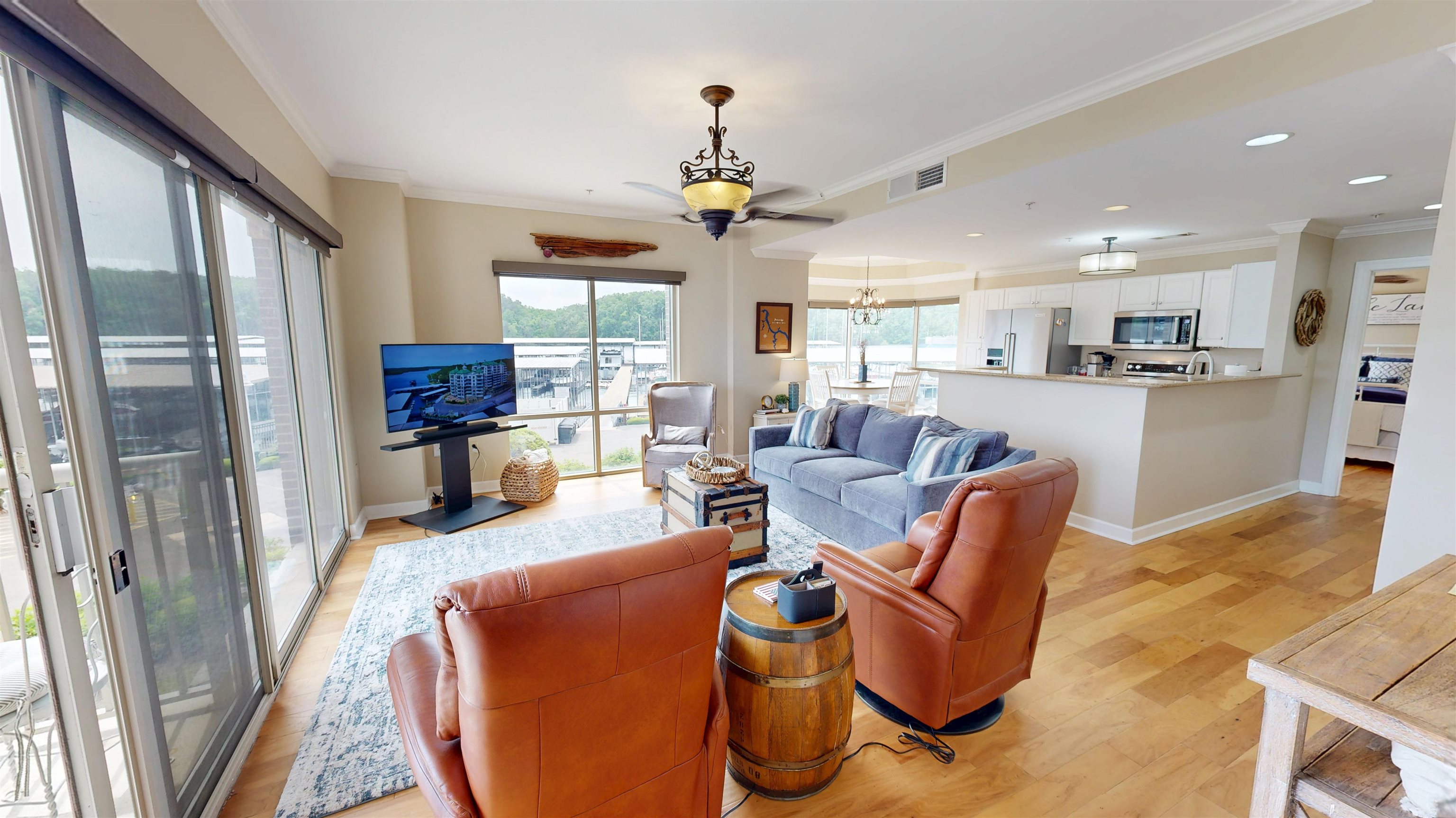325 Cr 380 L-103 Road, Unit L103 Iuka, MS 38852 - Photo 12 of 40 Open-concept living area featuring wood-finish flooring, a ceiling fan with integrated lighting, and crown molding